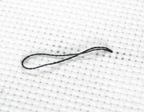 Pull your thread mostly through, leaving a length of thread with a loop on the back.