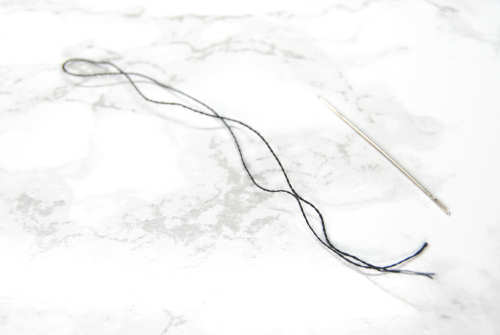 Prepare your thread by starting with a single strand and folding it in half.