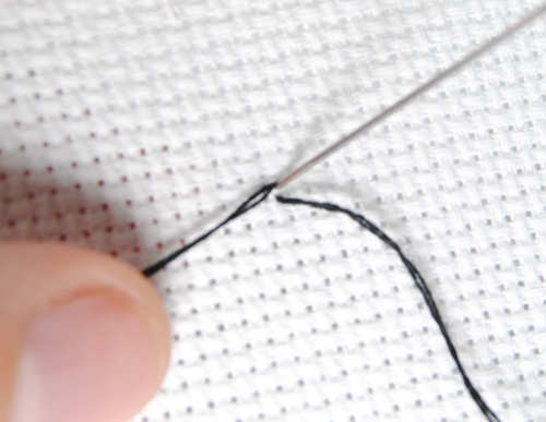 Bring your pin stitch back up from the edge of your square, then back through the middle.