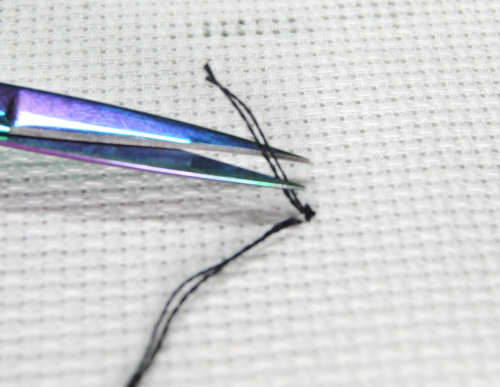 Trimming off the tail end of your pin stitch.