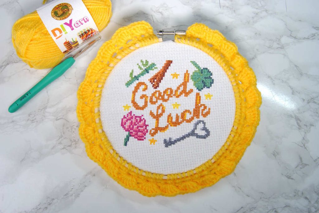 Front view of an embroidery hoop with a scalloped crochet edge.