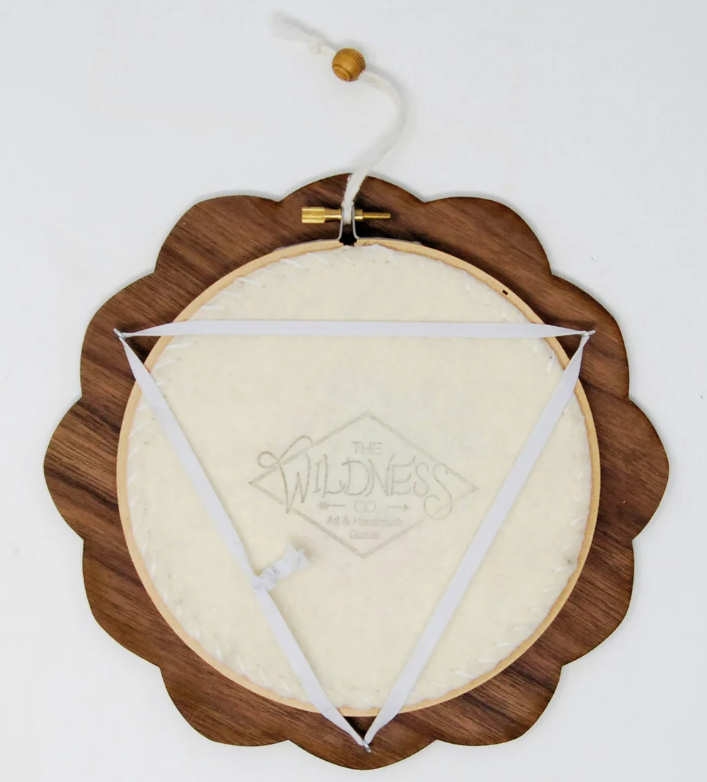The back of a hoop frame by stitchlifestudio, showing how the embroidery hoop is held in with elastic.