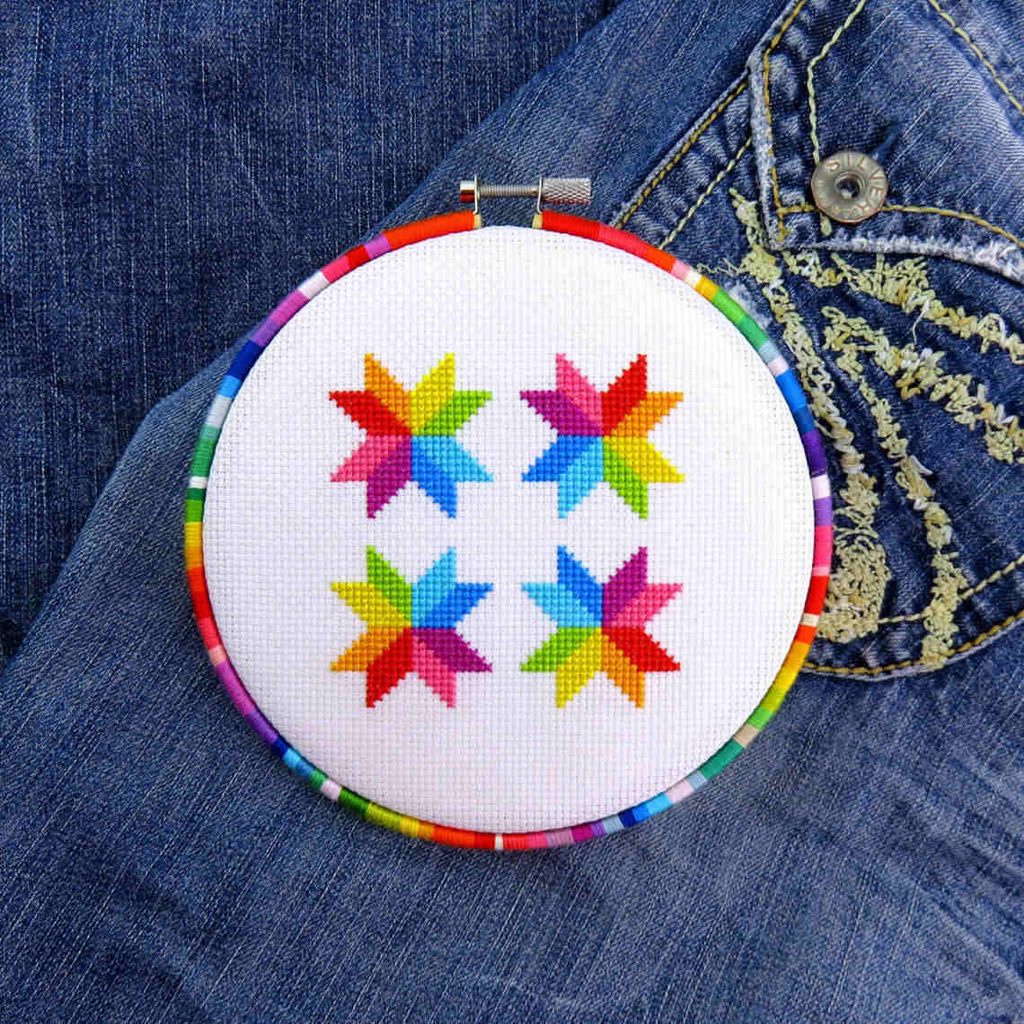 Example of an embroidery hoop wrapped in embroidery thread in rainbow colors by LuckyStarStitches.