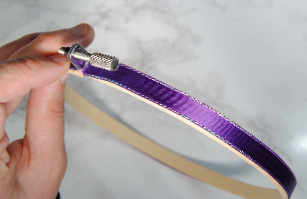 Glued ribbon flat along the side of an embroidery hoop