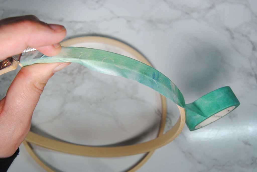 Folding washi tape around a wooden embroidery hoop