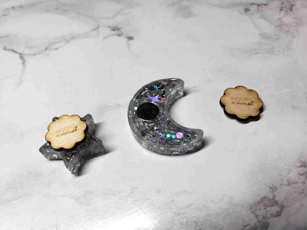 The back of some resin needle minders by Hoopsnmore, showing the engraved wooden backing magnets.