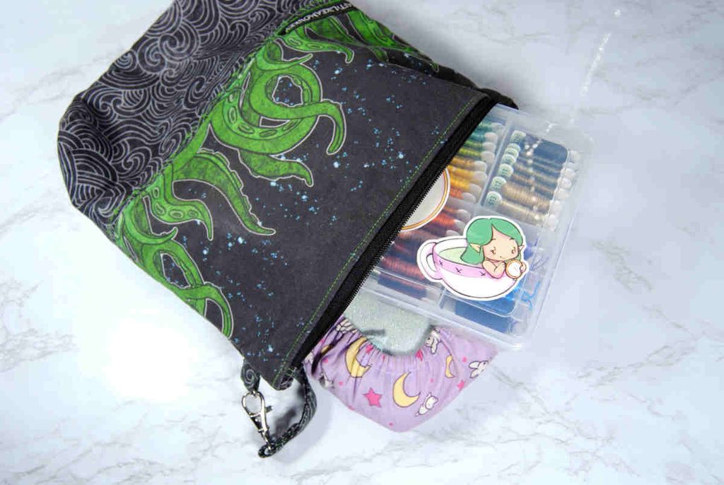 A zippered project bag by Craftylikeamonkey filled with cross stitch supplies.