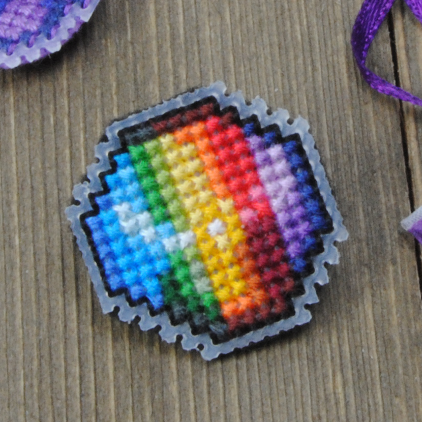 Close up of a cross stitched prismatic shard with a backstitched border.