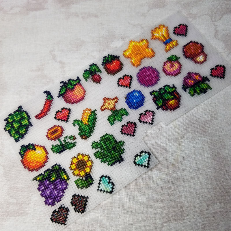 Several cross stitched designs all stitched on the same sheet of plastic.
