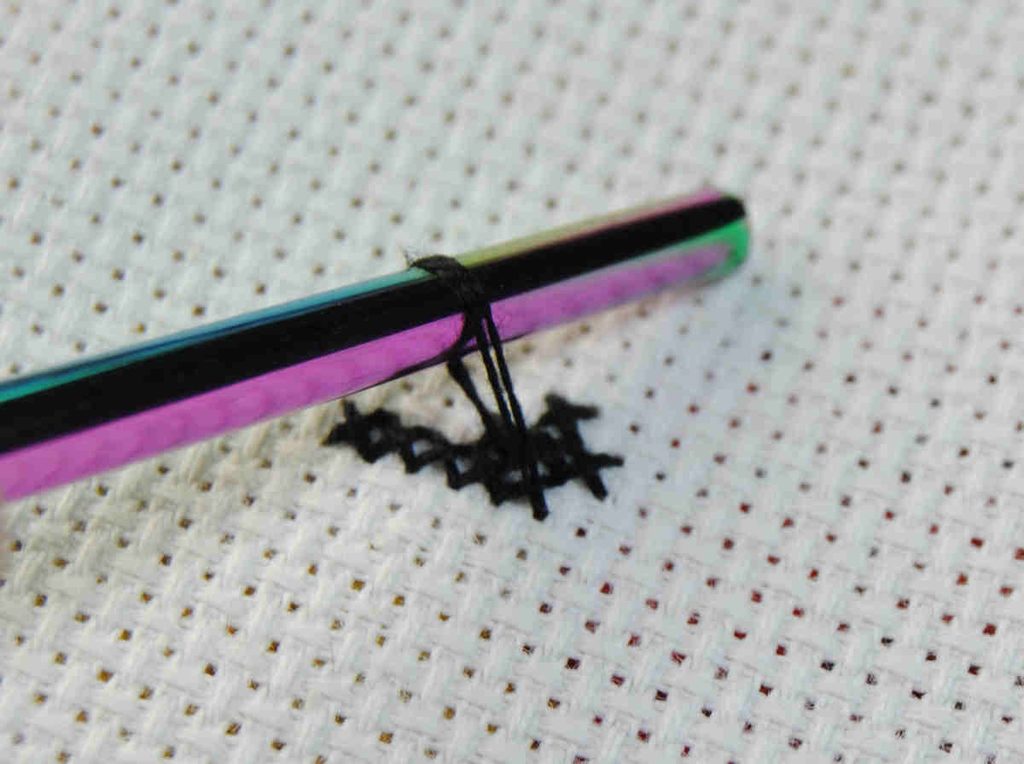 Closeup of railroading cross stitches using a laying tool