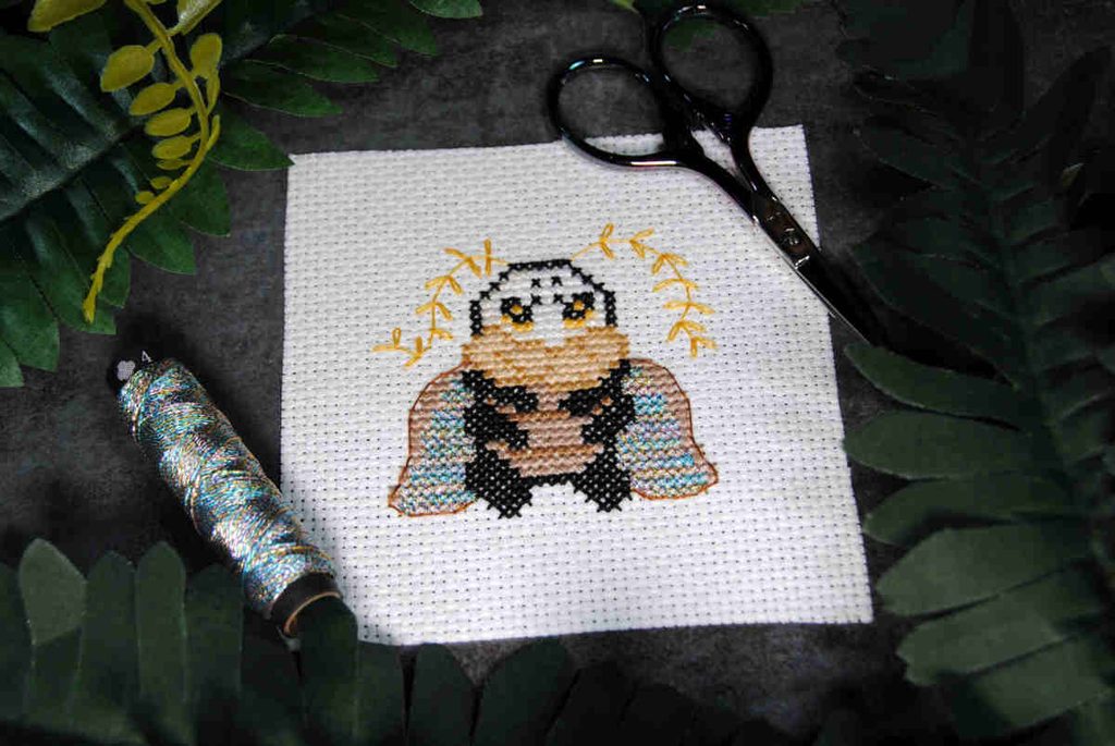 An artfight attack done in cross stitch and lazy daisies of a hollow knight character.