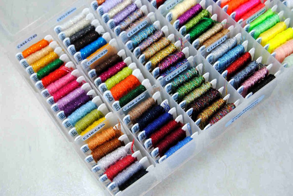 A bobbin box full of labeled dmc threads from the Mouliné Étoile and Light Effects line.
