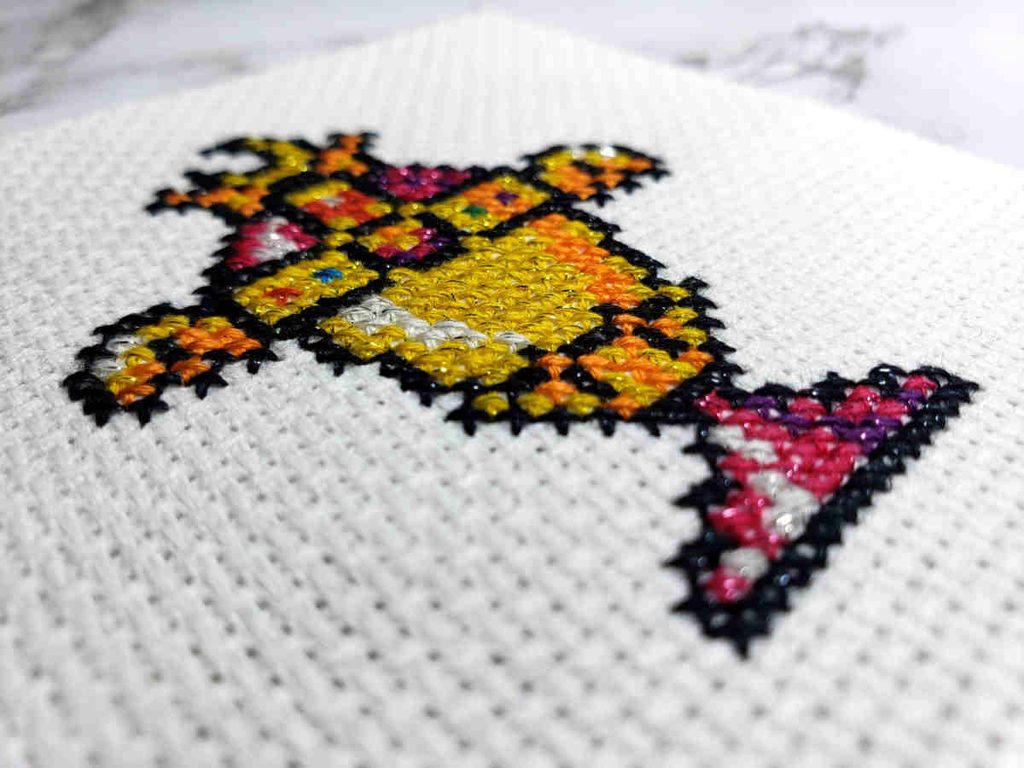 A cross stitch in Mouliné Étoile photographed at an angle to show the sparkle better.