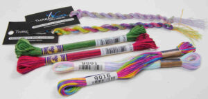 An assortment of variegated threads from brands DMC, Lecien Cosmo, and Threadworx