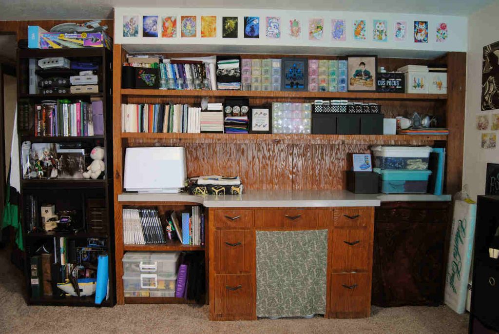 A built in desk being used for fabric and craft storage.