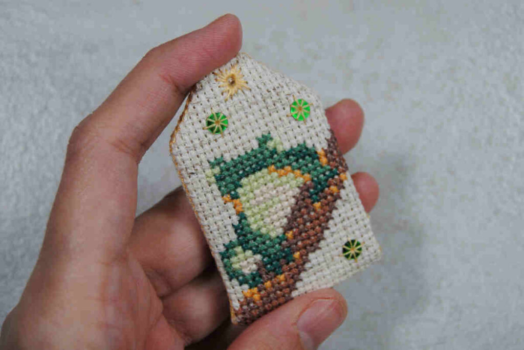 A finished cross stitch omamori prior to adding the classic omamori knot and cording.