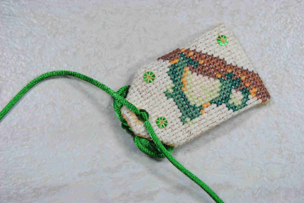 Secure the cording to your omamori by tying a simple knot.