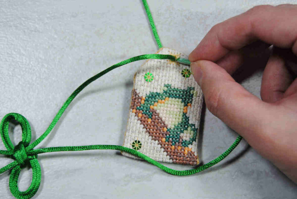 Feed second cord through your omamori eyelet using the angled tip of your aglet.