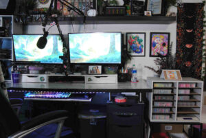 Office desk with two monitors in a craft room.