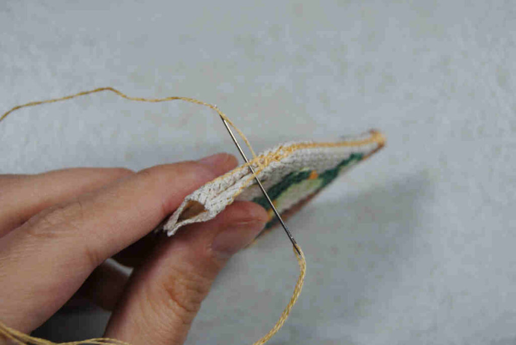 Demonstrating stitching aida together by stitching under a backstitch border.