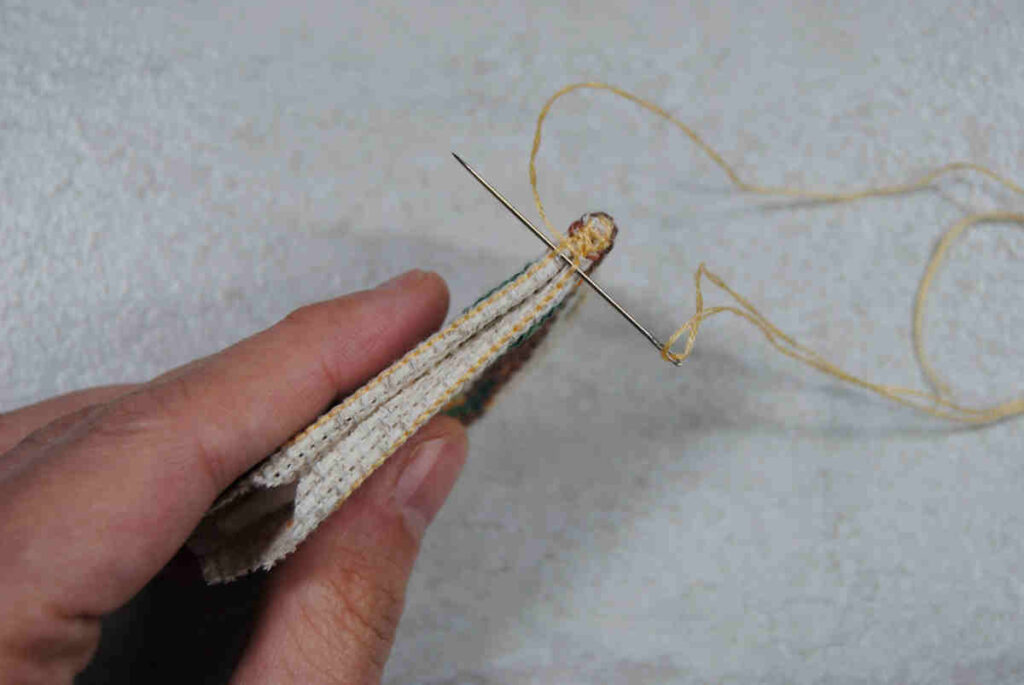 Demonstrating stitching aida together by stitching under a backstitch border.