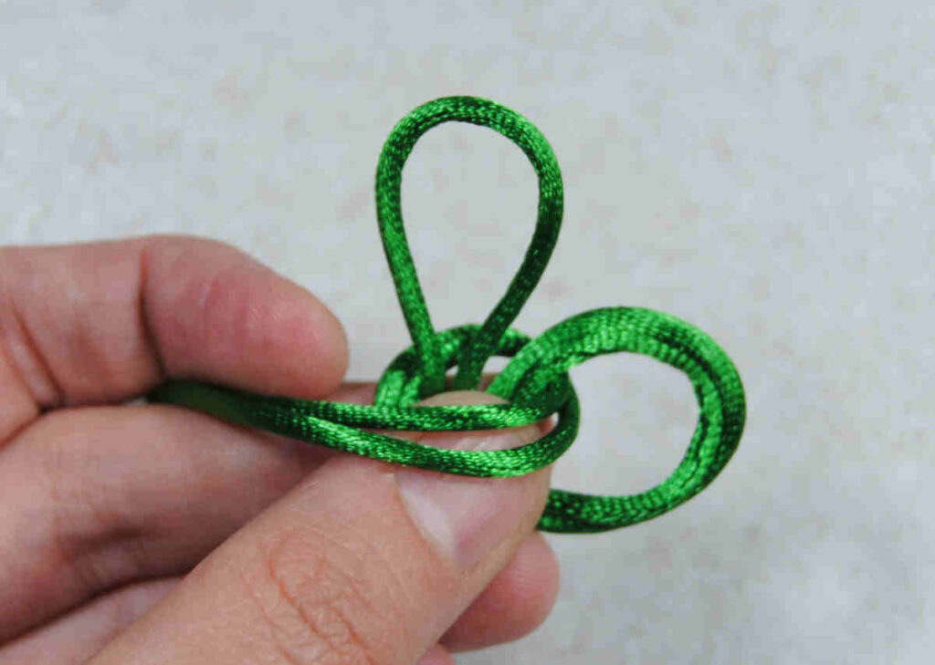 Demonstration of tying an omamori knot with silk cording.