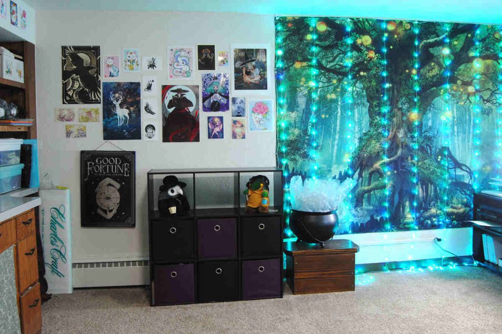 Concrete wall in a craft room covered in art prints.