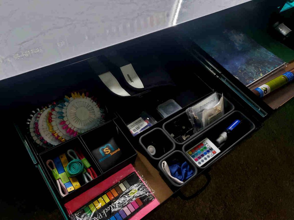 Drawers of a workbench storing photography accessories and props.