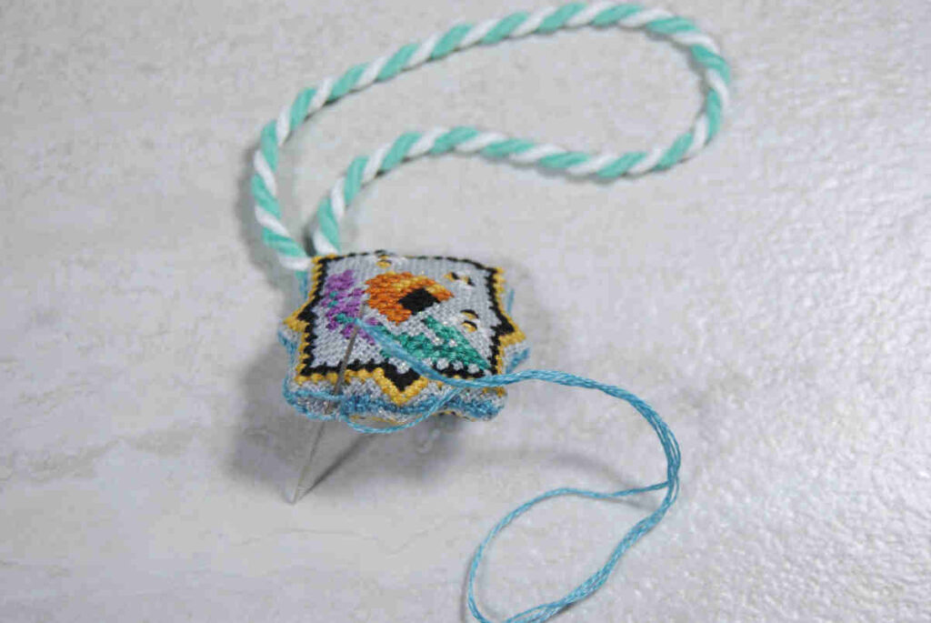 Stitching up the last side of a cross stitch scissor fob
