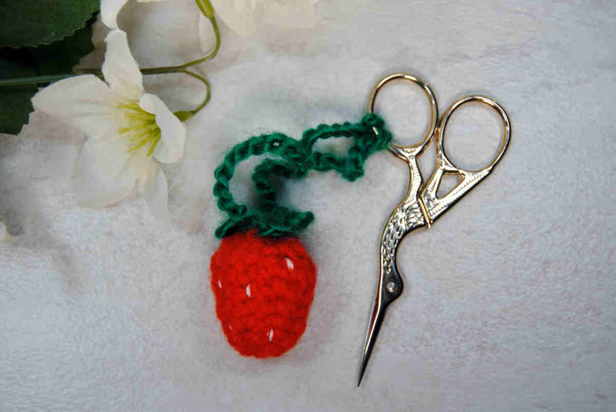 A crochet strawberry turned into a scissor fob