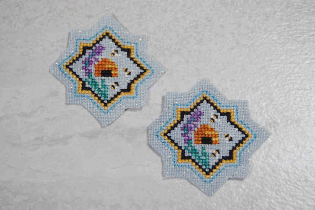 Two cross stitched mini beehive motifs trimmed to size.