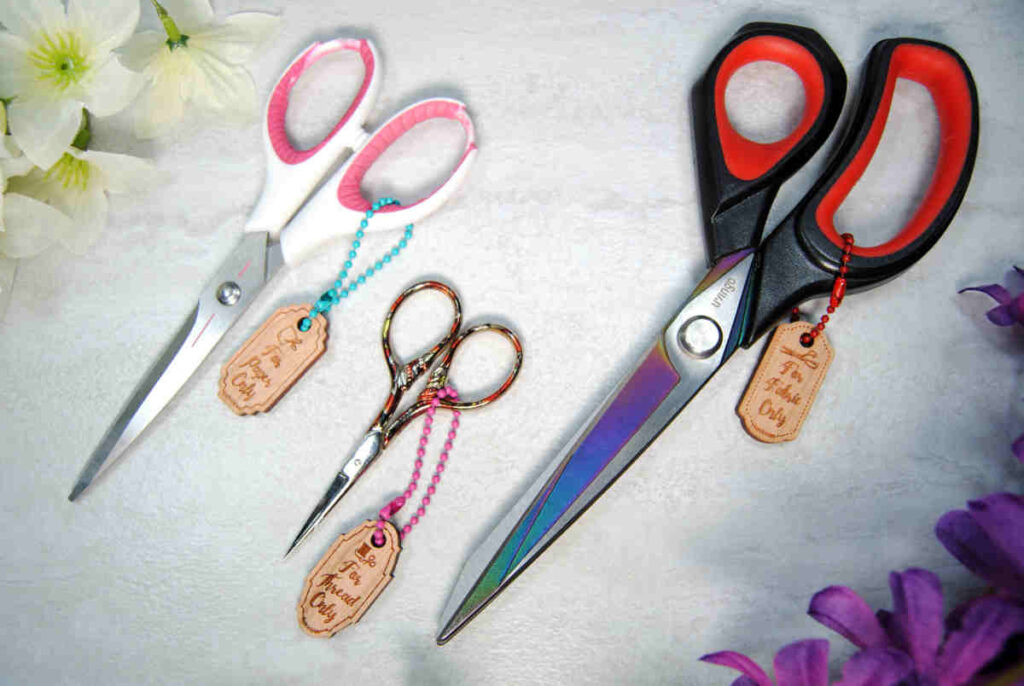 Wooden scissor fobs labeled "For Fabric Only"