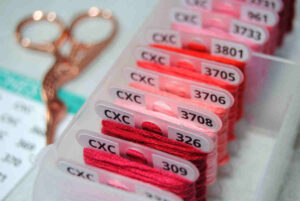 Closeup of a bobbin box full of CXC thread on labeled bobbins