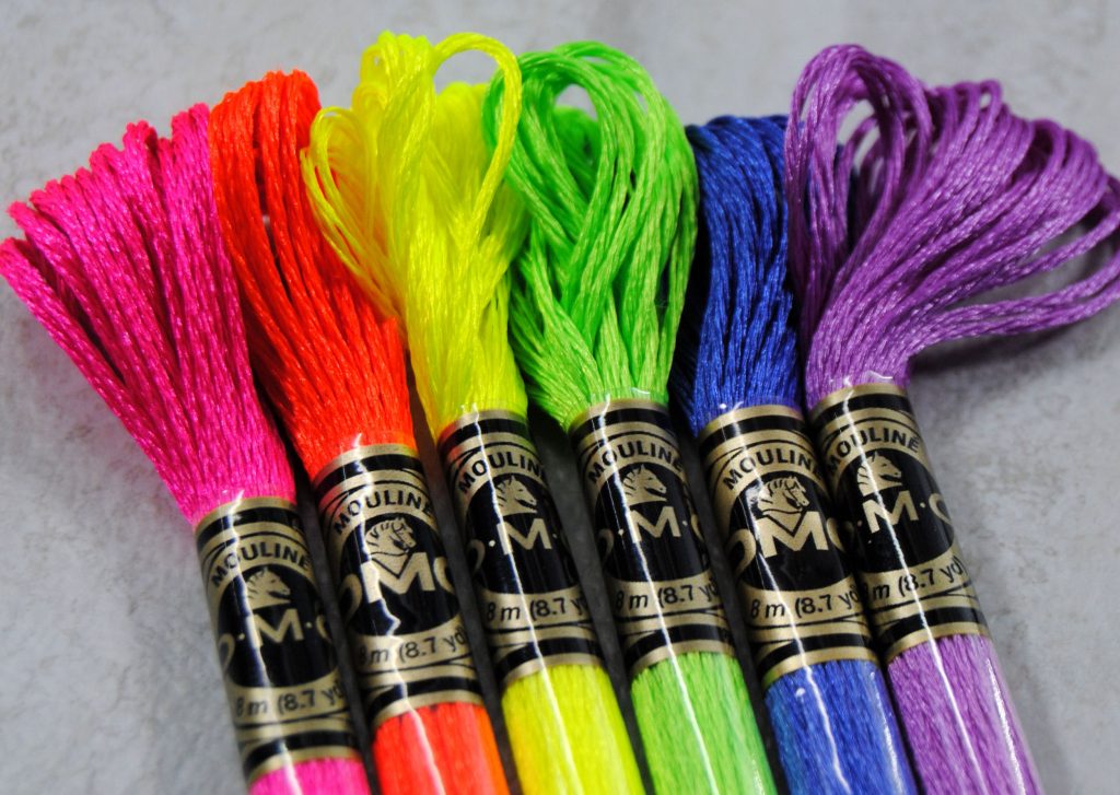 Close up of 6 skeins of DMC Light Effects from the Flourescent pack